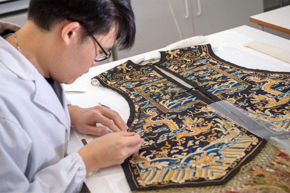 Centre for Textile Conservation - MPhil student supporting the highly embroidered panels from an 18th century waistcoat